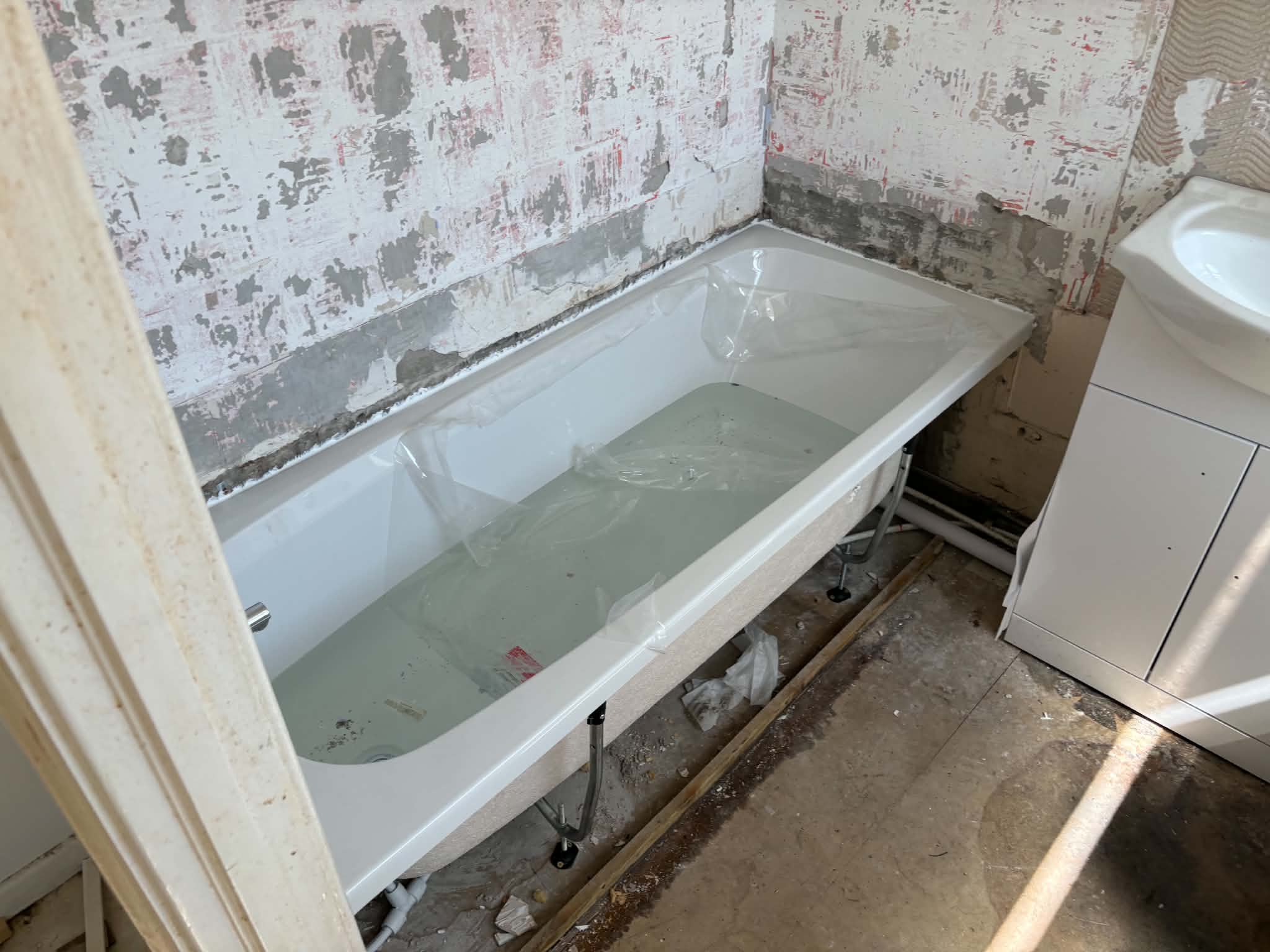 Bathroom before refit, walls stripped back
